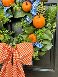 a wreath with oranges and green leaves on the front door