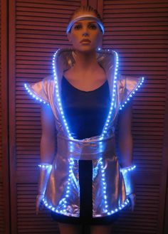 a mannequin with blue lights on it's chest and head, standing in front of a wall