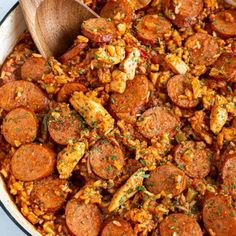 sausage and rice in a skillet with a wooden spoon on the side, ready to be eaten