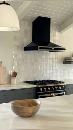 a bowl sitting on top of a kitchen counter next to an oven and range hood