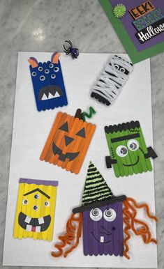 halloween crafts made out of pops sticks on a white paper with spider, monster and pumpkin faces