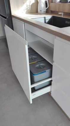 an open cabinet in the middle of a kitchen