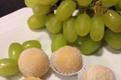 grapes and some pastries on a white plate