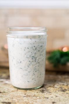 a jar filled with white sauce sitting on top of a counter