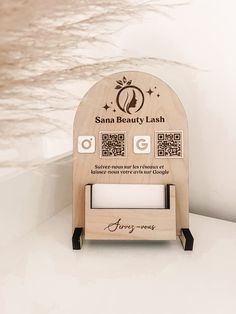 a wooden stand with an advertisement for santa beauty lashes on the front and back sides