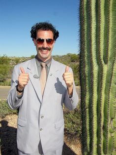 a man standing in front of a cactus with the caption very nice