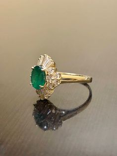 DeKara Designs Classic Handmade Art Deco Oval Emerald and Diamond Ring. This ring was entirely handmade by my father in the 1980's, anyone lucky enough to buy this ring will truly appreciate the workmanship and the beauty of this piece of art. Metal- 14K Yellow Gold, .583 Stones- 1 Oval Natural Green Emerald 1.23 Carats, 10 Baguette Diamonds, 10 Round Diamonds H-I Color SI1-SI2 Clarity 1.15 Carats. This ring is entirely put together piece by piece, and all the stones are carefully and expertly p Gia Certified 14k Gold Cluster Ring For Wedding, Heirloom Gold Emerald Ring With Halo Detail, Heirloom Gold Emerald Ring With Halo, Luxury 14k Stamped Cluster Ring For Wedding, Gia Certified Cluster Wedding Jewelry, Heirloom Style Emerald Ring With Halo For Formal Occasions, Heirloom Yellow Gold Gia Certified Cluster Ring, Heirloom Baguette Cut Emerald Ring For Wedding, Heirloom Baguette Cut Emerald Wedding Ring