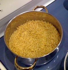 a pan filled with rice sitting on top of a stove next to a burner