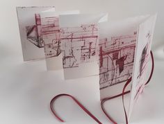 three pieces of paper with red ink on them sitting next to a pair of scissors