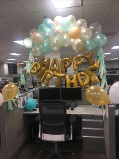 an office cubicle decorated with balloons and streamers that say happy birthday on the desk