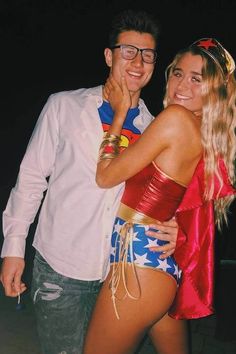 a man standing next to a woman wearing a superman costume on top of her chest