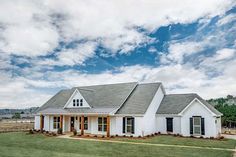 a white house sitting on top of a lush green field