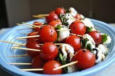 skewered tomatoes and mozzarella on toothpicks in a blue bowl