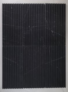 a black and white marble tile with vertical lines in the middle, on a wall