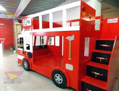 a red and white fire truck bunk bed with drawers on the bottom floor in a building