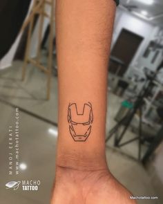 a small iron man tattoo on the wrist