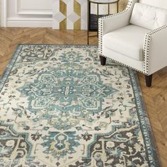 a white chair sitting on top of a hard wood floor next to a blue rug