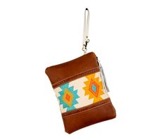 A delightful Southwest- and tribal-inspired design, in gorgeous colors, is the showpiece of this stunning bag. Tones of golden yellow, red and turquoise fill the upcycled woven rug, while panels of aged leather in warm cognac brown feature cross-stitched accents. Simply beautiful. The back is woven canvas in matching cognac brown. Zipper-close top with white leather wristlet carrying strap. Brown Rectangular Coin Purse For Travel, Brown Hand Tooled Pouch, Brown Woven Travel Pouch, Travel Woven Brown Pouch, Brown Hand-stitched Coin Purse For Daily Use, Brown Rectangular Coin Purse With Zipper, Traditional Brown Pouch For Everyday Use, Hand-stitched Brown Coin Purse For Daily Use, Travel Brown Woven Pouch