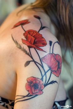 a woman's shoulder tattoo with red flowers and leaves on her arm, which reads 55 awesome shoulder tattoos