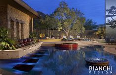 an outdoor swimming pool with lounge chairs and trees in the background at dusk or dawn