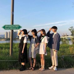 four people standing in front of a street sign