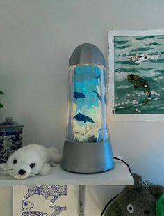 a lamp that is on top of a shelf next to a stuffed animal and some pictures