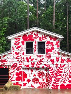 a red and white house with flowers painted on it's side is featured in instagram