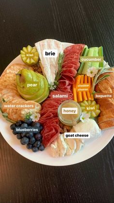 a white plate topped with lots of different types of meats and vegetables on top of each other