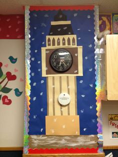 a clock mounted to the side of a wall next to a wooden shelf with magnets on it