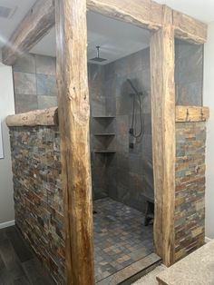 a walk in shower sitting inside of a bathroom next to a stone wall and floor