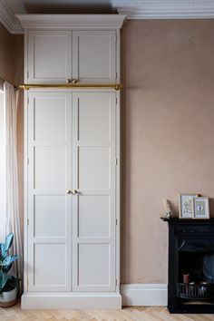 an empty room with a fireplace and large white closet doors on the wall next to a fire place