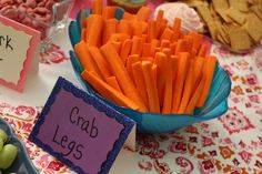 a table topped with bowls filled with carrots next to crackers and grapes on top of a table