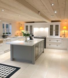 a large kitchen with white cabinets and an island