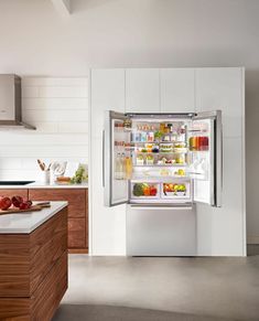 an open refrigerator in a kitchen with lots of food