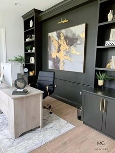 a home office with black walls and wooden flooring, built in shelving units