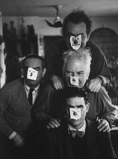 an old black and white photo shows three men with tape on their faces, one man has his nose taped off