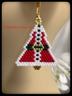 a cross stitch christmas ornament hanging from a mannequin