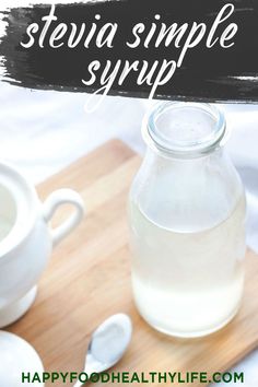 a bottle of stevia simple syrup sitting on a cutting board with spoons next to it