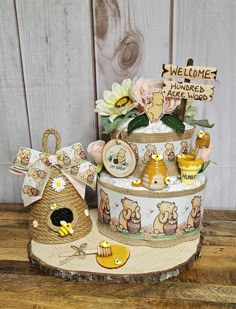 a three tiered cake decorated with winnie the pooh images and bees on it