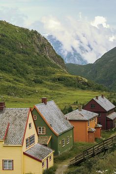 several small houses in the mountains on a cloudy day