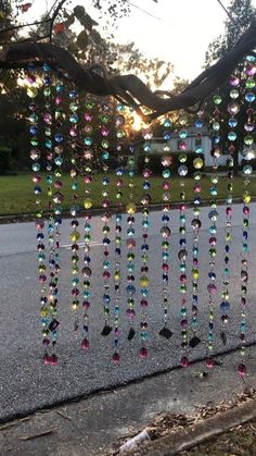 a wind chime hanging from the side of a tree in front of a street