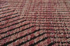 a close up view of a red and black checkered rug with small white dots on it