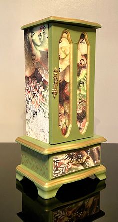 a green and gold clock sitting on top of a black table next to a white wall