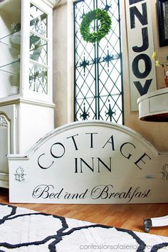 a sign that says cottage inn bed and breakfast in front of a cabinet with wreaths on it