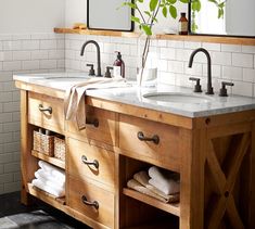 a bathroom with two sinks and wooden cabinets