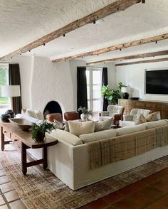 a living room filled with furniture and a flat screen tv mounted on the wall over a fireplace