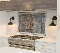 a stove top oven sitting inside of a kitchen next to a counter and two lights