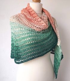 a white mannequin wearing a green and pink shawl