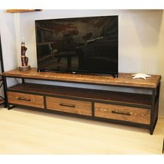 a flat screen tv sitting on top of a wooden entertainment center next to a shelf