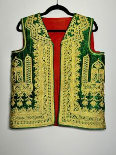 Made in Afghanistan, this a rare find vintage sleeveless waistcoat. Hand embroidery on velvet. A very antique piece in mint condition.  Measurements in inches (flat):  Shoulder: 15 Bust: 20 Length: 24 Note: Worn and minor signs of wear. Traditional Sleeveless Festive Vest, Traditional Sleeveless Vest For Festive Occasions, Festive Sleeveless Embroidered Vest, Festive Vest With Intricate Embroidery, Sleeveless Vest With Intricate Embroidery For Festivals, Festive Sleeveless Vest With Intricate Embroidery, Festive Embroidered Sleeveless Vest, Sleeveless Embroidered Vest For Festive Occasions, Festive Vintage Fitted Vest